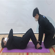 검사자가 무릎을 굽힌채로 바닥에 등을 대고 누워있고 측정자는 검사자의 발목을 잡고있다