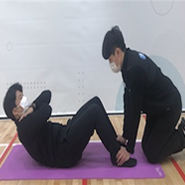 검사자가 양팔을 십자모양으로 교차하여 가슴 앞에 모으고 두 손은 어깨 위에 올린채로 상체를 일으키고 있다