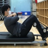 검사자가 측정자 없이 기구 발걸이에 발목을 고정시키고 상체를 일으키고 있다