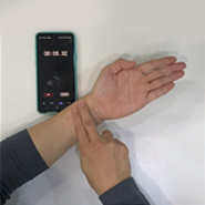 검사자가 오른손 검지와 중지로 왼손 손목의 요골동맥을 짚고 있다