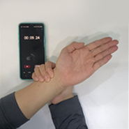 검사자가 스탑워치를 이용해서 시간을 측정하며 요골동맥의 심박수를 세고 있다